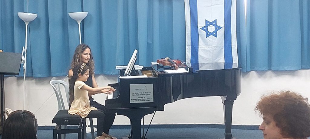 תלמידה ומורה מנגנות על פסנתר